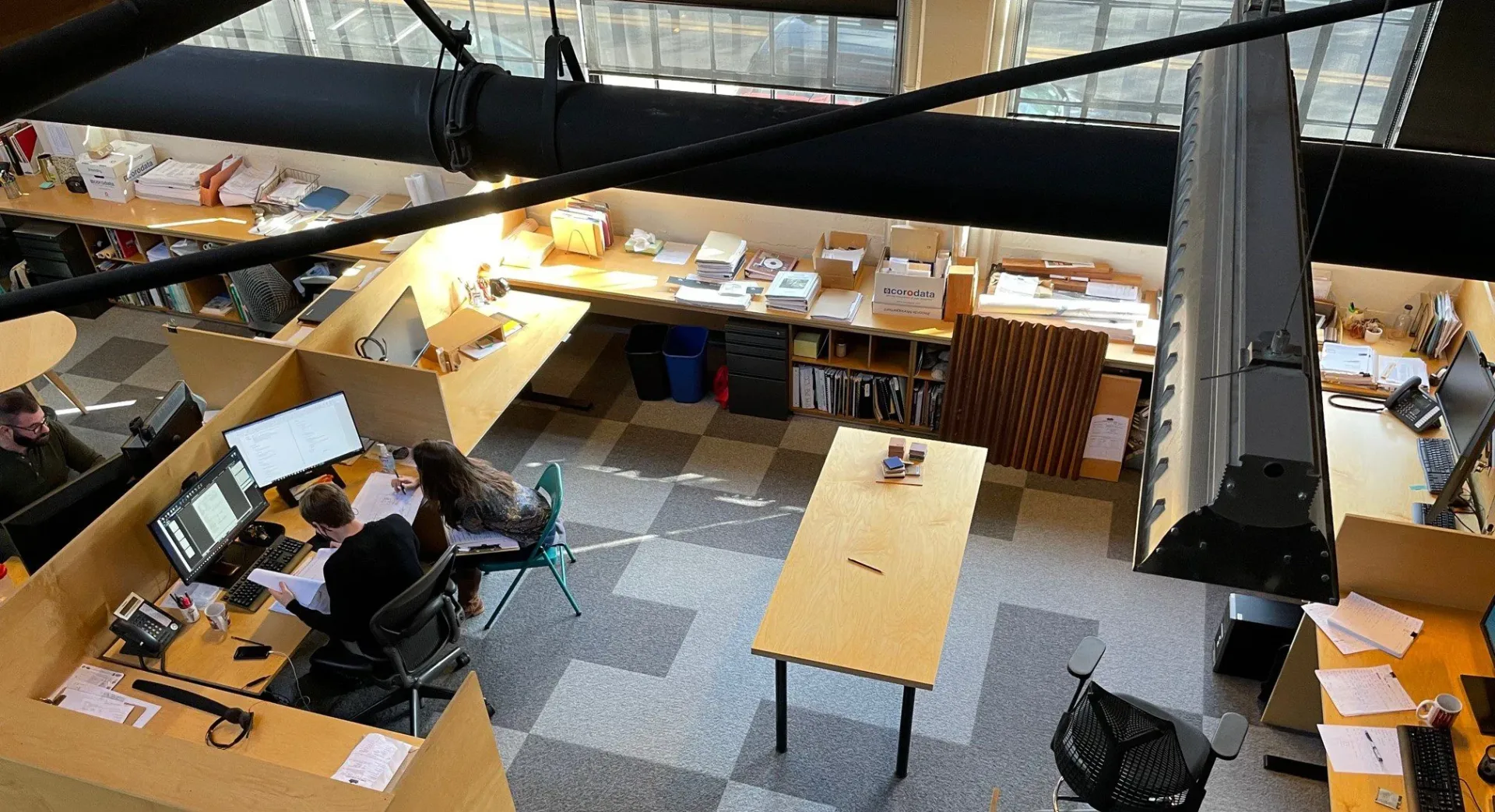 The Siegel & Strain studio in Emeryville, California - staff at work at drafting desks below the exposed roof structure